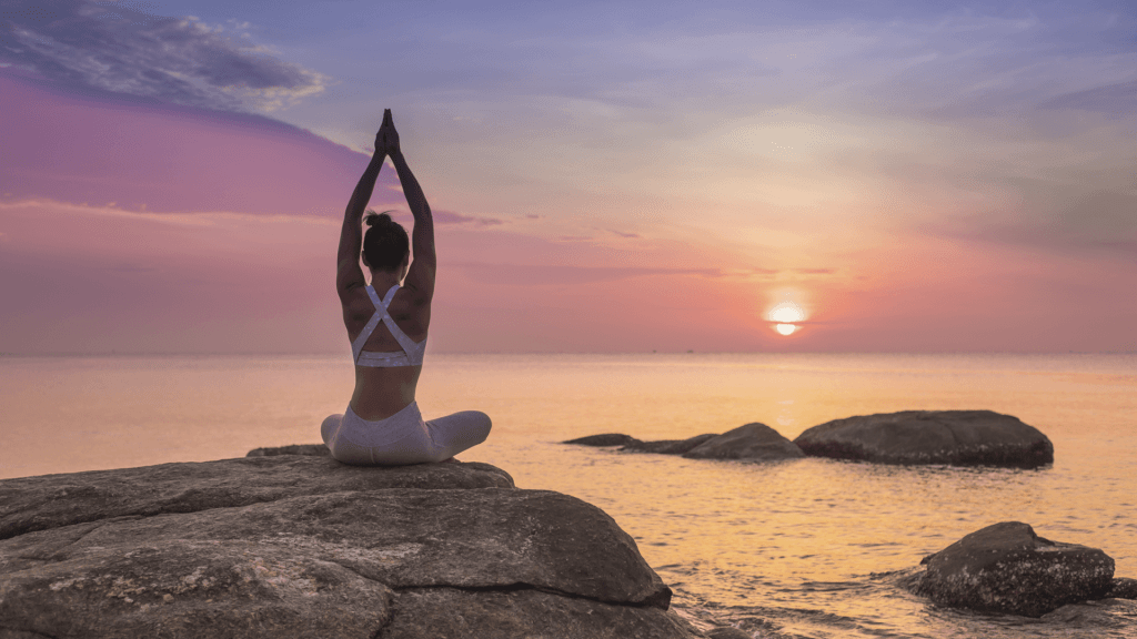 woman meditating rocks sea