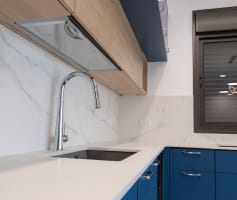 מטבח מודרני עם ארונות כחולים וברז נירוסטה