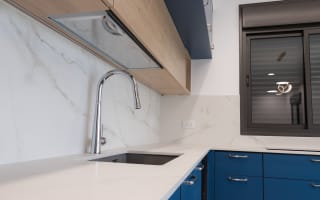 מטבח מודרני עם ארונות כחולים וברז נירוסטה