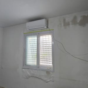 קיר צבוע עם חלון ומזגן, הכנה לצביעה