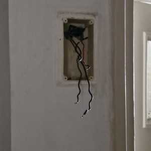 חוטי חשמל יוצאים מקופסה בקיר