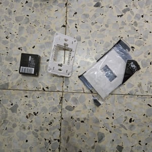 חלקי חשמל וכלים על רצפה, כולל מתג חשמלי