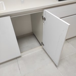 ארון מטבח פתוח עם דלת תלויה על צירים