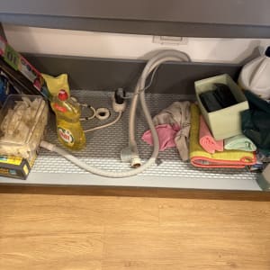 צינור וכלי ניקוי מתחת לכיור במטבח