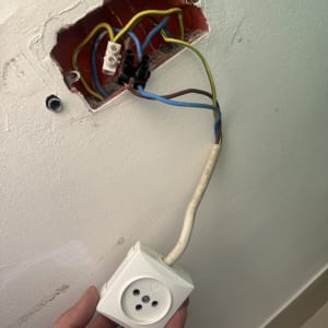 שקע חשמלי עם חוטים חשופים בקיר