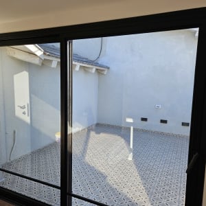 דלי צהוב על רצפה מרוצפת ליד קיר חיצוני