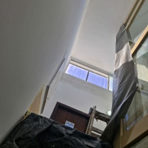 סולם עץ ליד קיר צבוע לבן עם סימני צבע