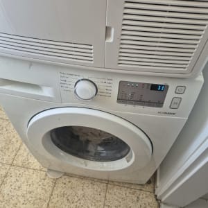 מכונת כביסה בחדר כביסה עם רצפת אריחים