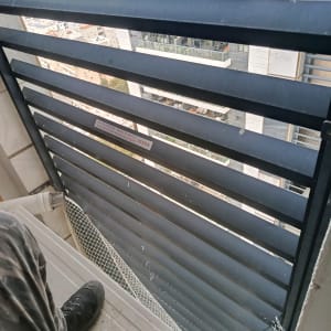 רשת למניעת יונים מותקנת על מרפסת בניין