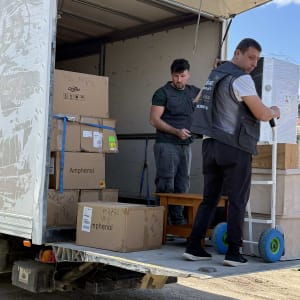 שני אנשים פורקים קופסאות ממשאית הובלה