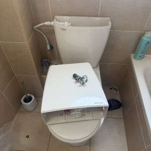 תמונה של שירותים עם מכסה פתוח וכלי עבודה