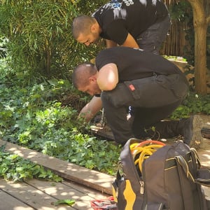שני אנשים עובדים בגינה עם כלים וציוד