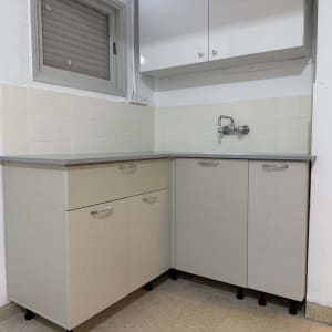 מטבח קטן עם ארונות כיור וברז