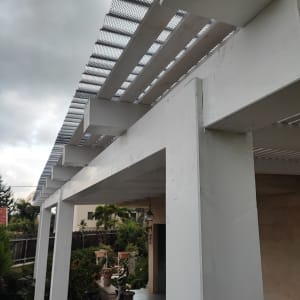 פרגולה מעץ לבן עם רשת מתכת עליונה