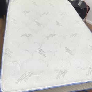 מזרן עם בקבוקי ניקוי וצינור על הרצפה