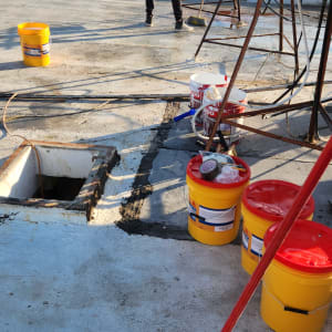 אדם עובד על גג עם דליים וכלי עבודה