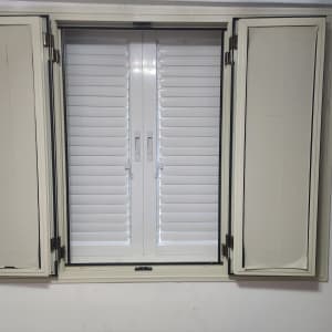חלון אלומיניום עם תריסים סגורים ודלתות פתוחות