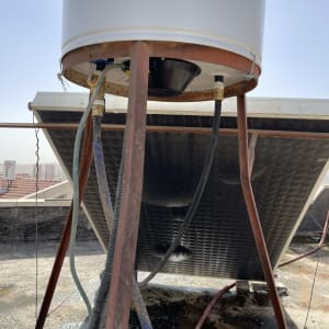 דוד שמש מותקן על גג עם צינורות ומסגרת מתכת