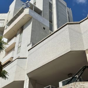 בניין גבוה עם דגל ישראל על מרפסת