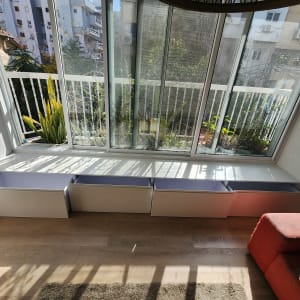 ארונות אחסון מתחת לחלון זכוכית בדירה מוארת