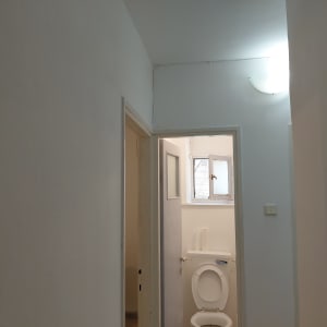 מסדרון עם דלת פתוחה לשירותים, קירות צבועים בלבן