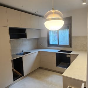 שיש במטבח מודרני עם ארונות בהירים ותאורה תלויה