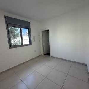 חדר ריק עם רצפת אריחים וחלון