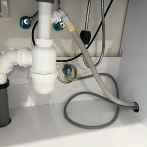 צנרת מתחת לכיור עם חיבורים וצינורות