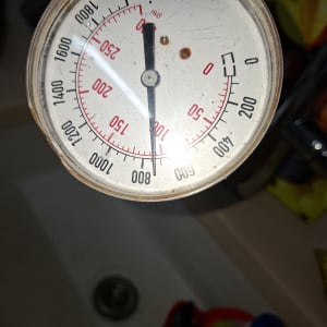 מד לחץ מים עם מחוגה על רקע כיור