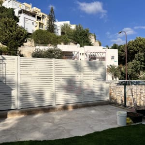 גדר אלומיניום בחצר עם כלים ודשא