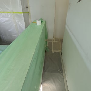 חדר מוכן לצביעה עם כיסוי ירוק על רהיטים