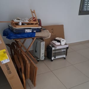 ארגזים, חפצים ורהיטים מרוכזים בפינת חדר בדירה