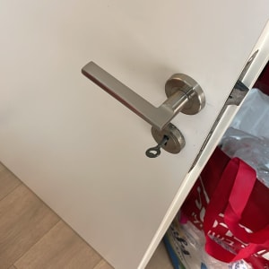 ידית דלת מתכתית עם מפתח בדלת לבנה