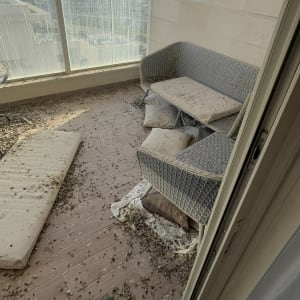 מרפסת מלוכלכת עם רהיטים וכריות מלוכלכות