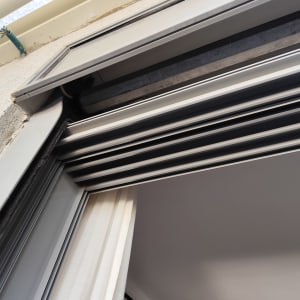 תריסים מותקנים על חלון עם מסגרת מתכת