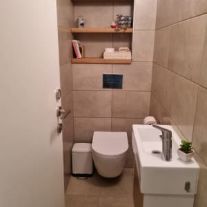 מדפים מעץ על קיר בחדר שירותים