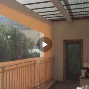 מרפסת עם גג פלסטיק שקוף ותמיכה מעץ