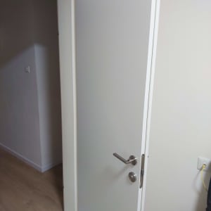 דלת לבנה פתוחה עם ידית מתכת כסופה