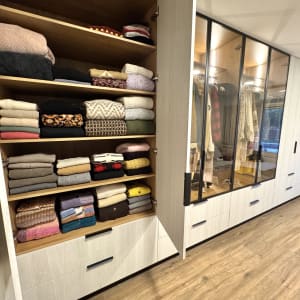 ארון בגדים עם מדפים מסודרים וסוודרים מקופלים