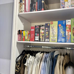 ארון בגדים מסודר עם משחקים וצעצועים על המדף