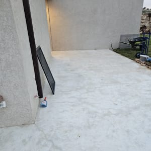 בקבוק חומר ניקוי על רצפת בטון ליד קיר חיצוני