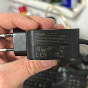 מטען ASUS עם כבלים ומקלדת ברקע