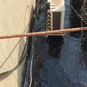 זפת שחורה על גג עם כבלים ומזגן