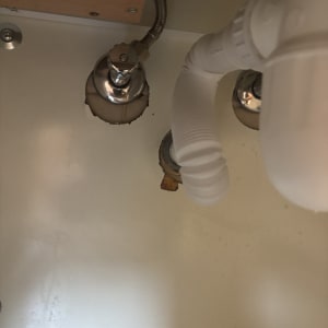 צנרת מתחת לכיור עם חיבורים וצינור גמיש