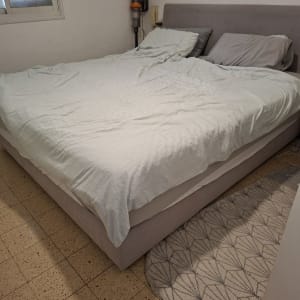 חדר שינה עם מיטה זוגית ושואב אבק על הקיר