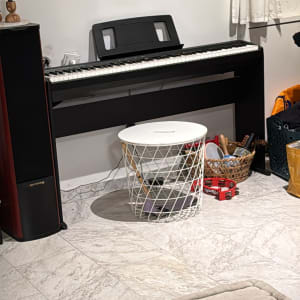 פסנתר חשמלי שחור עם כיסא לבן ותוף מרים אדום