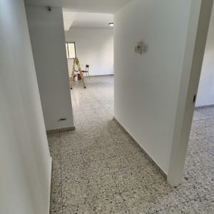 סולם צהוב ודלי צבע בחדר ריק