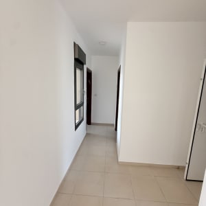 מסדרון עם קירות לבנים ורצפת אריחים