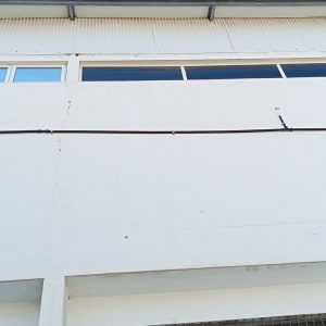 צינור שחור מחובר לקיר לבן עם תפסנים