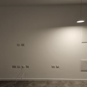 קיר צבוע בלבן עם תאורה עליונה